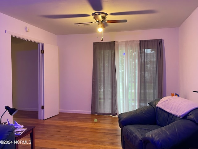 sitting room with ceiling fan and hardwood / wood-style flooring