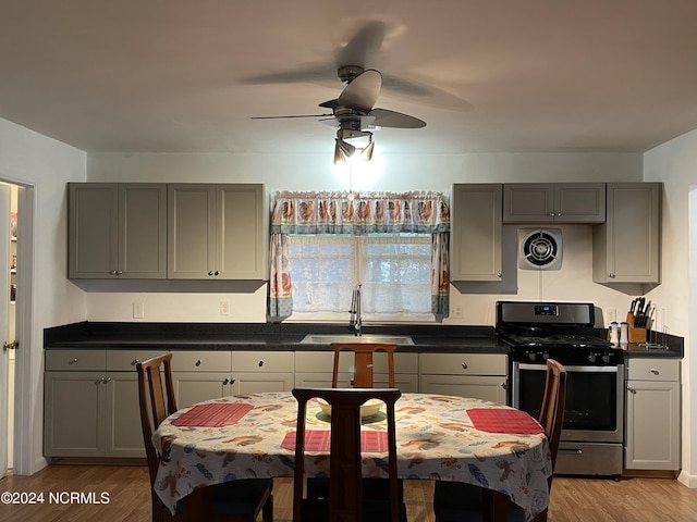 kitchen featuring light wood-style floors, gray cabinets, a sink, and gas range