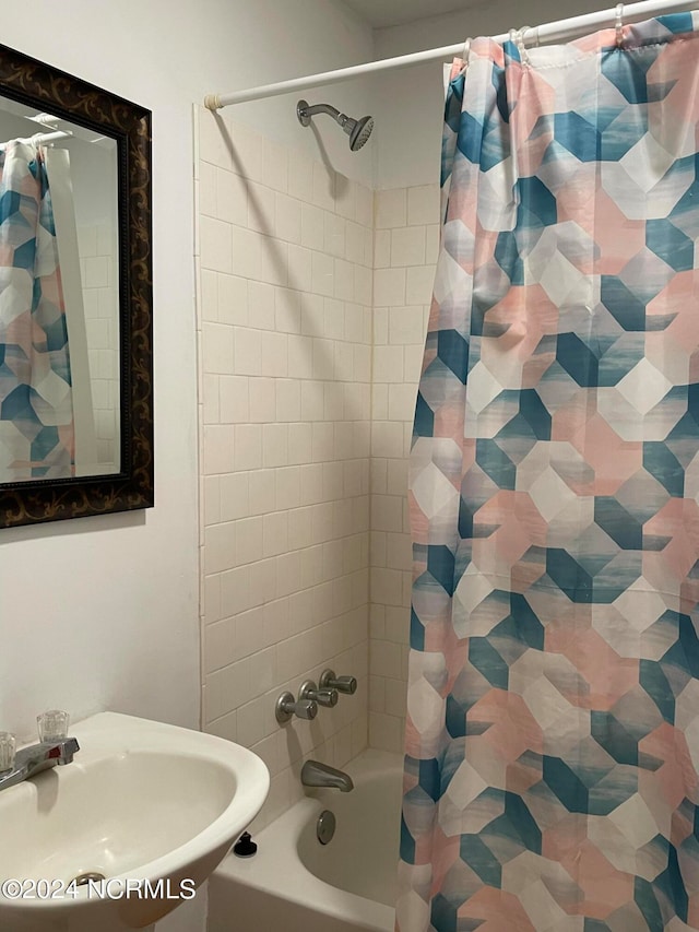 bathroom with shower / bath combination with curtain and sink