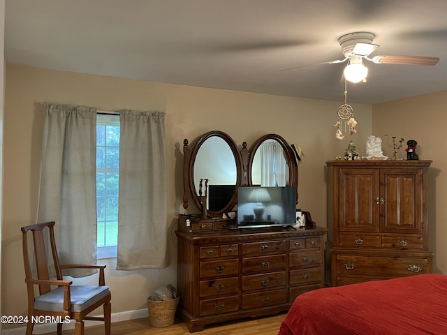 bedroom with a ceiling fan, baseboards, and light wood finished floors