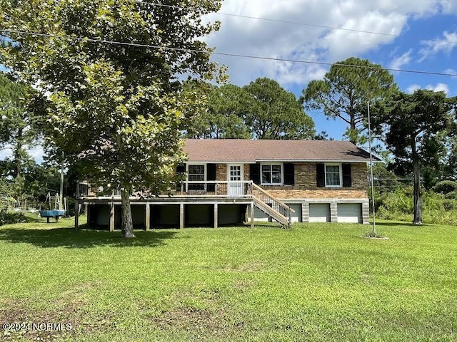 rear view of house with an attached garage, stairway, and a lawn