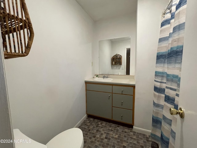 bathroom with curtained shower, vanity, toilet, and baseboards