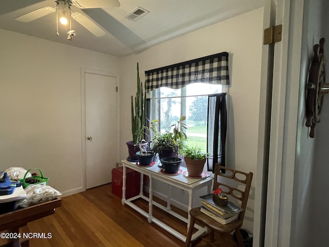 home office with a ceiling fan, visible vents, and wood finished floors