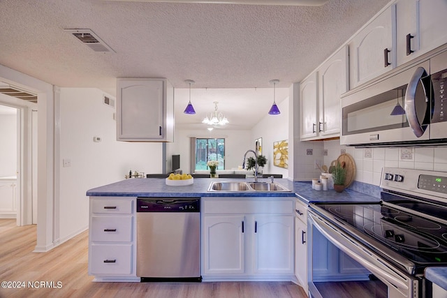 kitchen featuring white cabinets, sink, appliances with stainless steel finishes, and an inviting chandelier