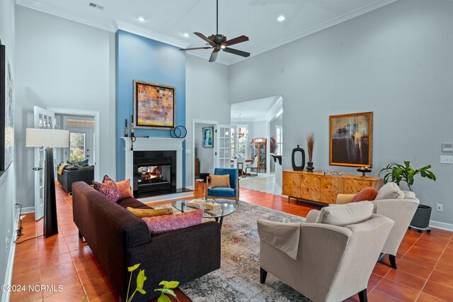 tiled living room featuring crown molding, ceiling fan, and a towering ceiling