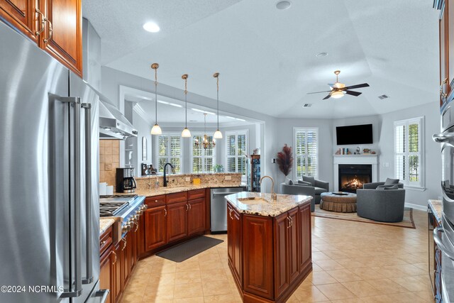 kitchen with decorative light fixtures, appliances with stainless steel finishes, light stone countertops, and ceiling fan