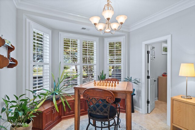 dining room with plenty of natural light, ornamental molding, and an inviting chandelier