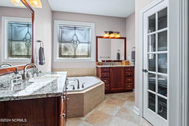 bathroom with vanity, tiled tub, and tile patterned floors