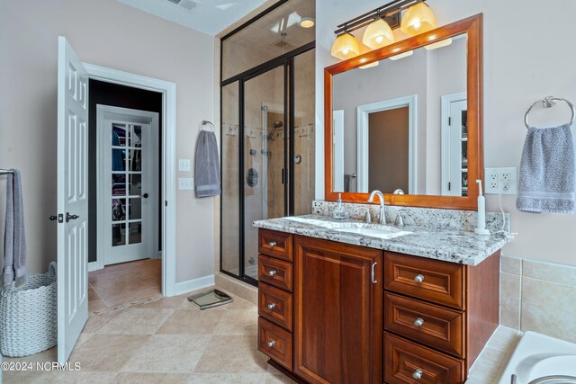 bathroom with tile patterned flooring, separate shower and tub, and vanity