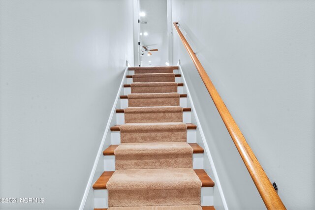 staircase featuring ceiling fan