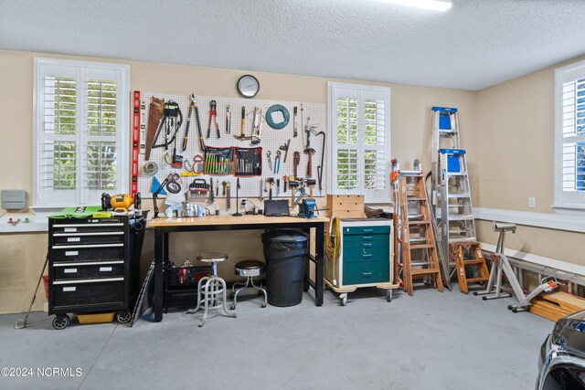 interior space featuring a textured ceiling, a workshop area, and concrete flooring