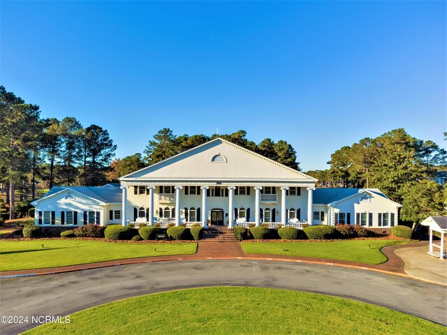 neoclassical home featuring a front lawn and a porch