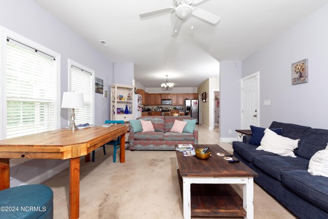 living room featuring ceiling fan with notable chandelier