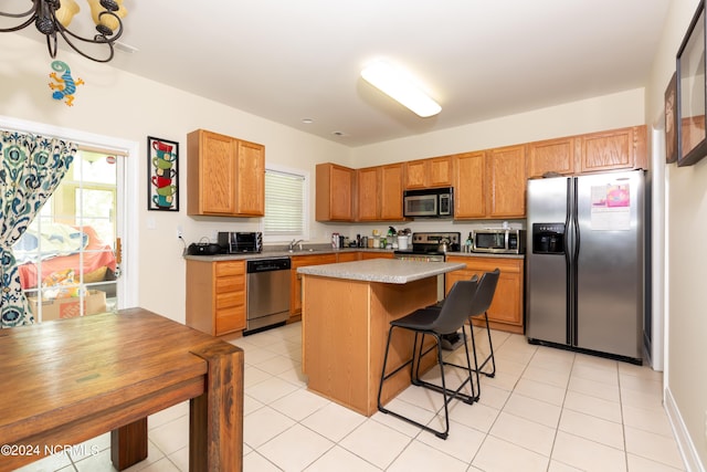 kitchen with a breakfast bar, sink, a center island, plenty of natural light, and stainless steel appliances