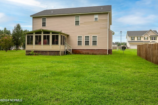 back of property with a sunroom and a yard