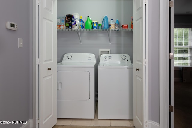 clothes washing area with light tile patterned floors and washing machine and clothes dryer