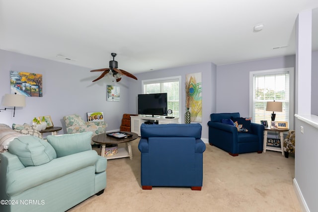 living room with ceiling fan, a healthy amount of sunlight, and light carpet