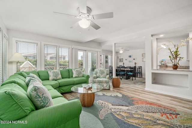 living room featuring wood-type flooring and ceiling fan