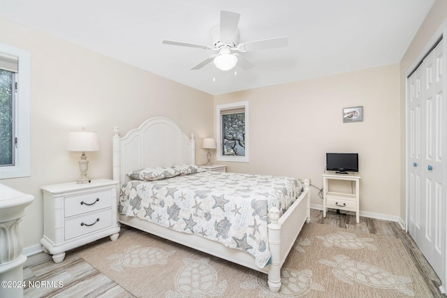 bedroom featuring ceiling fan, a closet, and light wood-type flooring