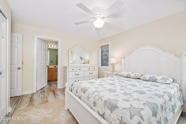 bedroom with light wood-type flooring, ceiling fan, and connected bathroom