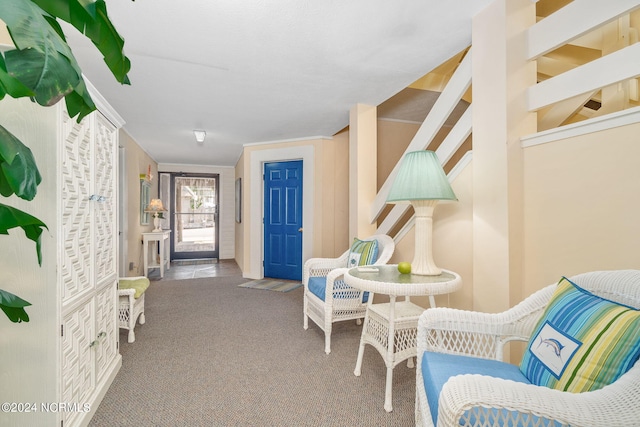 sitting room with carpet flooring and crown molding