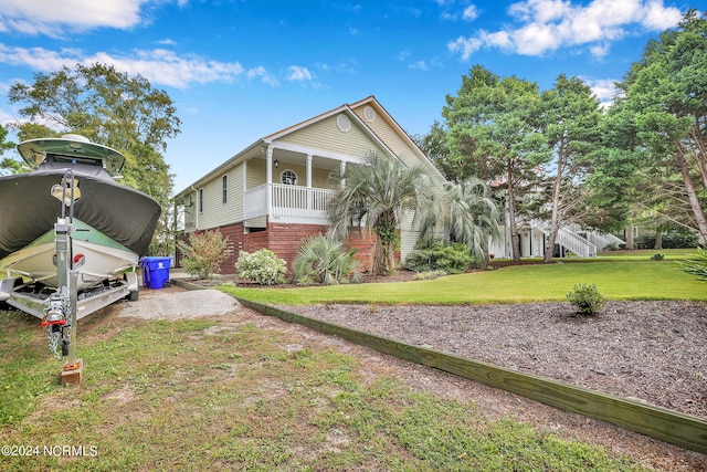 view of front of home featuring covered porch and a front lawn