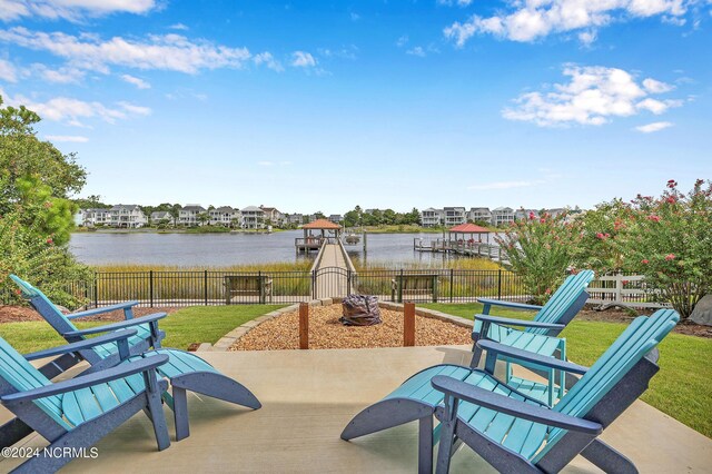 view of patio featuring an outdoor fire pit, a water view, and a dock