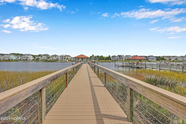 view of dock featuring a water view, a residential view, and a gazebo