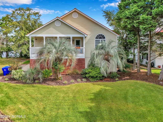 view of front of property featuring covered porch and a front lawn