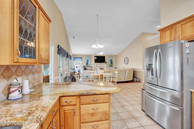 kitchen with decorative backsplash, a chandelier, light stone countertops, stainless steel fridge with ice dispenser, and light tile patterned floors