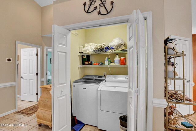 clothes washing area with independent washer and dryer and light tile patterned floors