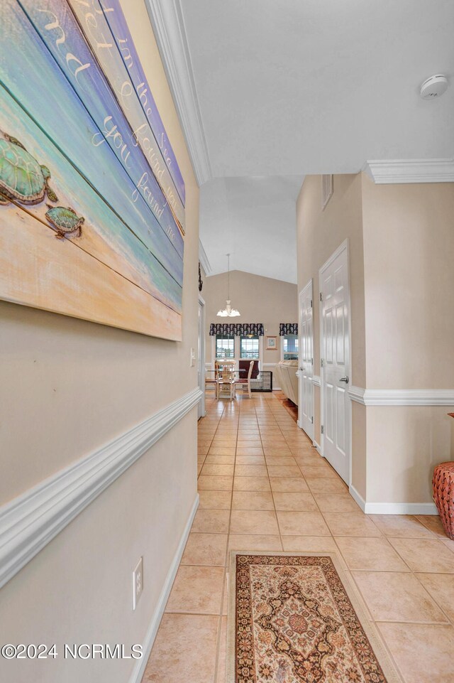 corridor with lofted ceiling and light tile patterned floors