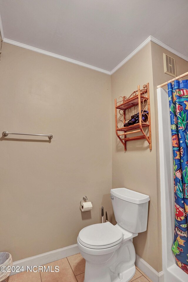 bathroom featuring tile patterned flooring, toilet, a shower with shower curtain, and crown molding