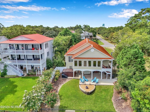 back of property featuring a yard, a hot tub, a fenced backyard, and a patio