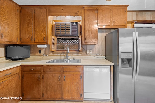 kitchen featuring dishwasher, stainless steel refrigerator with ice dispenser, and sink