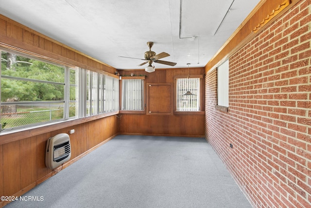 unfurnished sunroom with heating unit and ceiling fan