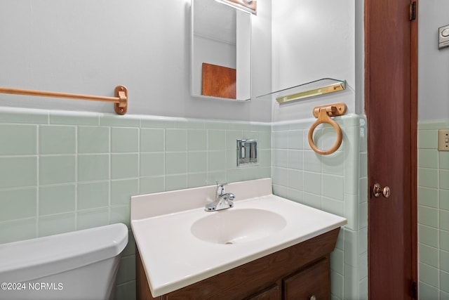 bathroom featuring tile walls, toilet, and vanity