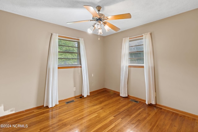 unfurnished room featuring ceiling fan, light wood-type flooring, and a textured ceiling