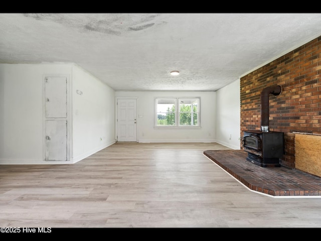9348 NC Highway 210, Rocky Point, NC 28457 - unfurnished living room with a textured ceiling, wood finished floors, a wood stove, and baseboards