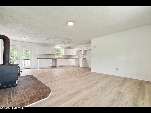 9348 NC Highway 210, Rocky Point, NC 28457 - living area with a wood stove, light wood-style flooring, baseboards, a textured ceiling, and recessed lighting