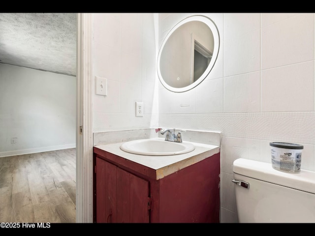 9348 NC Highway 210, Rocky Point, NC 28457 - half bath featuring vanity, toilet, a textured ceiling, and wood finished floors
