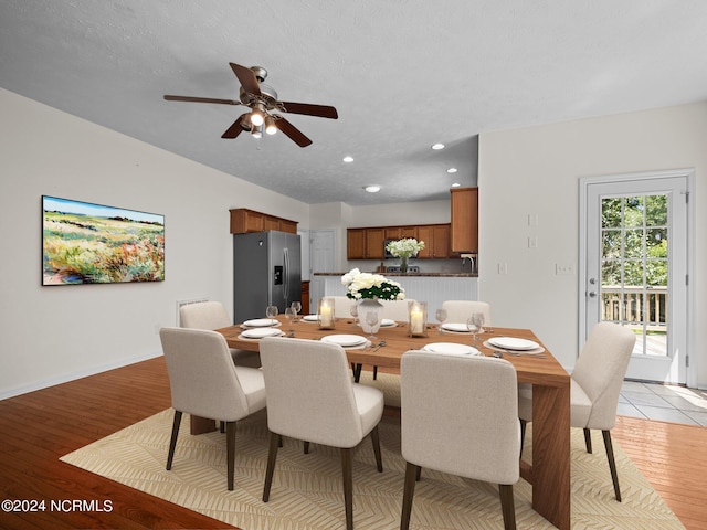 dining area featuring light wood-type flooring, a textured ceiling, and ceiling fan