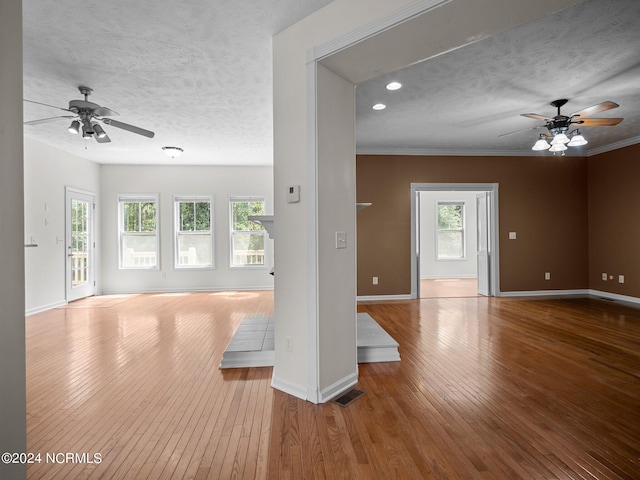 unfurnished room with light hardwood / wood-style flooring, ceiling fan, and a textured ceiling