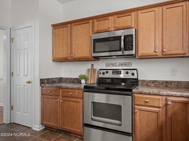 kitchen with stainless steel appliances and dark tile patterned floors