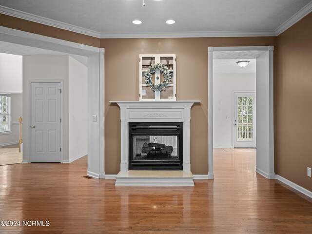 unfurnished living room with light hardwood / wood-style floors, a multi sided fireplace, and ornamental molding