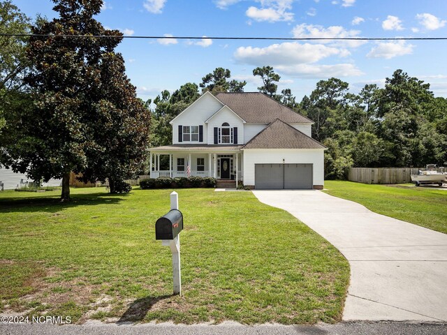 view of front facade with a front yard, a garage, and covered porch