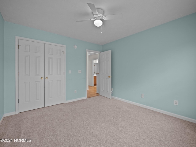 unfurnished bedroom with light carpet, a closet, and ceiling fan