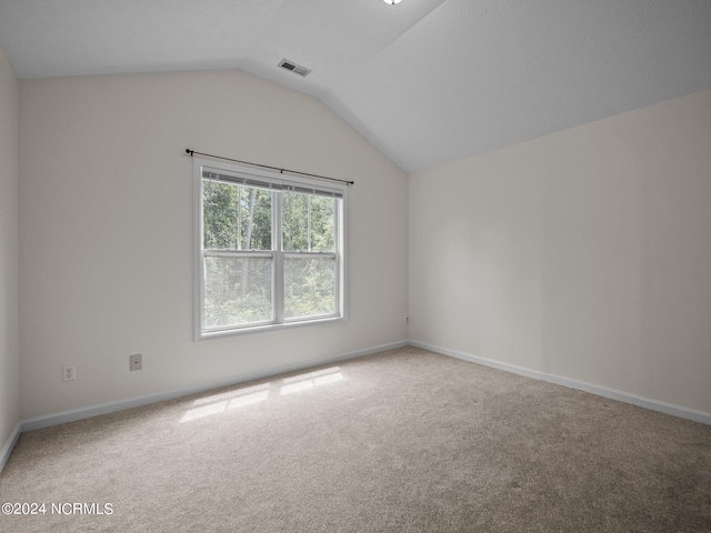 unfurnished room featuring vaulted ceiling and carpet floors