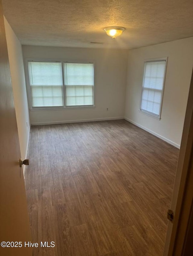 714 Walnut St, Laurinburg, NC 28352 - spare room with a textured ceiling, dark wood finished floors, and baseboards