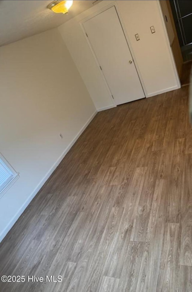 714 Walnut St, Laurinburg, NC 28352 - spare room with wood finished floors, vaulted ceiling, and baseboards